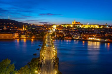 Charles Köprüsü 'nden geçerek Çek Cumhuriyeti' nin Prag Şatosu 'na doğru giden insanların günbatımı görüntüsü.