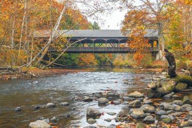 Mohican Kapalı Köprüsü sonbaharda Mohican Nehri 'nin açık çatalına yayılıyor. Mohican Eyalet Parkı. Perrysville 'de. Ohio mu? ABD