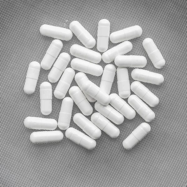 Bílé Vitamíny Pilulky Perforovaném Pozadí — Stock fotografie