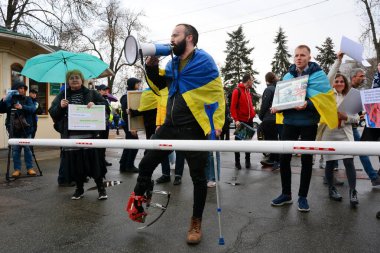 İnsanlar, 8 Nisan 2023 'te Kyiv-Pechersk Lavra' nın girişinde toplanırken pankart okuyorlar. - Ukrayna hükümeti, Rus otoritesi altındaki Ukrayna Ortodoks Kilisesi 'nin üyesi olan rahiplerin