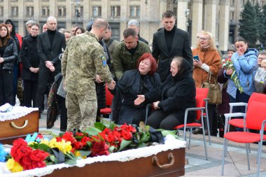 İnsanlarla çevrili bir kadın, Ukrayna 'nın Verkhovna Rada' sının eski yardımcısı ve Ukrayna Silahlı Kuvvetleri askeri Oleg Barna ve kardeşi Valery Khodorov için 21 Nisan 2023 'de Bağımsızlık Meydanı, Kyiv' de düzenlenen veda töreninde ağlar..