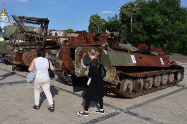 İnsanlar, 15 Haziran 2023 Perşembe günü Ukrayna 'nın merkezindeki Mykhailivska Meydanı' nda sergilenen hasarlı bir Rus tankına bakarken görülüyor.
