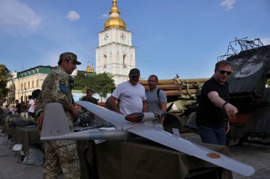 İnsanlar, 15 Haziran 2023 Perşembe günü Ukrayna 'nın başkenti Kyiv' e savaş sembolü olarak yerleştirilmiş Rus insansız hava araçlarına bakıyorlar.
