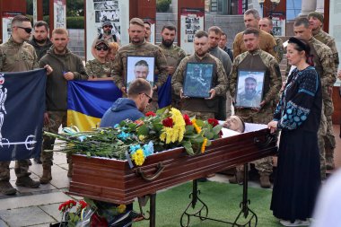 Kyiv 'deki Bağımsızlık Meydanı' nda vedalaşan asker Yury Semenyuk 'un cenazesiyle tabutun yanında ağlayan akrabalar ve arkadaşlar görülüyor.