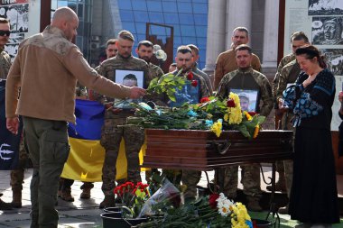 Kyiv 'deki Bağımsızlık Meydanı' nda vedalaşan asker Yury Semenyuk 'un cenazesiyle tabutun yanında ağlayan akrabalar ve arkadaşlar görülüyor.