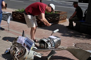 KYIV, UKRAINE - 23 Ağustos 2023: İnsanlar Kyiv 'in merkezinde savaş sembolü olarak gösterilen imha edilmiş bir Rus füzesine bakıyorlar..