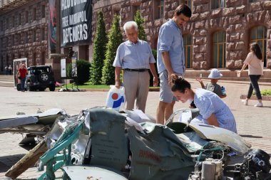 KYIV, UKRAINE - 23 Ağustos 2023: İnsanlar Kyiv 'in merkezinde savaş sembolü olarak gösterilen imha edilmiş bir Rus füzesine bakıyorlar..