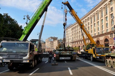 KYIV, UKRAINE - 23 Ağustos 2023: Ukrayna askeri personeli, Kyiv 'in merkezinde sergilenen Rus ordusunun imha edilmiş teçhizatının vinçleriyle birlikte boşaltılıyor. 