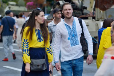 24 Ağustos 2023 'te Ukrayna' nın Kyiv kentinde Ukrayna 'nın Bağımsızlık Günü' nde Khreshchatyk Caddesi 'nde sergilenen tahrip edilmiş bir Rus zırhlı aracının yanından geçen bir adam ve kadın görülüyor..