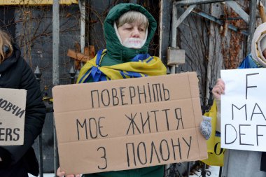 17 Aralık 2023 'te Ukraynalı savaş esirlerini desteklemek için Ukrayna' nın başkenti Kyiv 'de bir kadın pankart taşıyor.. 