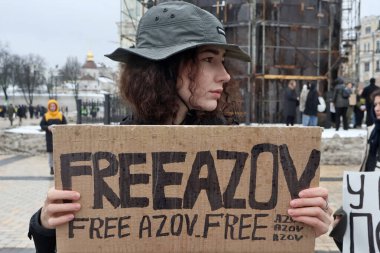 17 Aralık 2023 'te Ukraynalı savaş esirlerini desteklemek için Ukrayna' nın başkenti Kyiv 'de bir kadın pankart taşıyor.. 