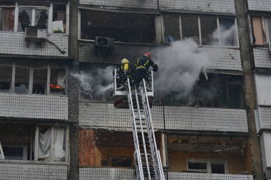 İtfaiyeciler, Rusya 'nın Ukrayna' yı işgali sırasında 2 Ocak 2024 'te Kyiv şehir merkezindeki bir füze saldırısında yıkılan çok katlı bir binada çıkan yangını söndürmeye çalıştılar..