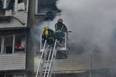İtfaiyeciler, Rusya 'nın Ukrayna' yı işgali sırasında 2 Ocak 2024 'te Kyiv şehir merkezindeki bir füze saldırısında yıkılan çok katlı bir binada çıkan yangını söndürmeye çalıştılar..