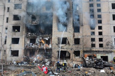 İtfaiyeciler, Rusya 'nın Ukrayna' yı işgali sırasında 2 Ocak 2024 'te Kyiv şehir merkezindeki bir füze saldırısında yıkılan çok katlı bir binada çıkan yangını söndürmeye çalıştılar..