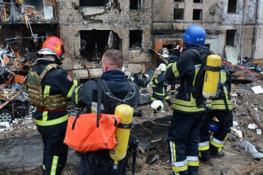 İtfaiyeciler, Rusya 'nın Ukrayna' yı işgali sırasında 2 Ocak 2024 'te Kyiv şehir merkezindeki bir füze saldırısında yıkılan çok katlı bir binada çıkan yangını söndürmeye çalıştılar..