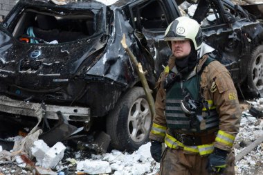 2 Ocak 2024 'te Kyiv' in merkezinde Rusya 'nın Ukrayna işgalinin arka planına karşı roket saldırısı sonucu yıkılan yüksek binaların yakınlarındaki bir itfaiyeci..