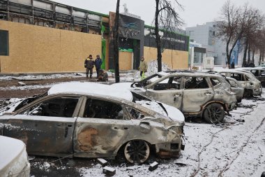 KYIV, UKRAINE - 20240103: 3 Ocak 2024 'te Ukrayna' nın başkenti Kyiv 'de Rus füze saldırısının ardından hasar görmüş bir araba galerisinin yakınında duran yanmış arabalar. 2 Ocak sabahı, Rus kuvvetleri Kyiv 'e büyük bir füze saldırısı düzenledi..