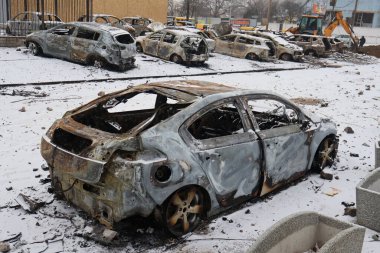 KYIV, UKRAINE - 20240103: 3 Ocak 2024 'te Ukrayna' nın başkenti Kyiv 'de Rus füze saldırısının ardından hasar görmüş bir araba galerisinin yakınında duran yanmış arabalar. 2 Ocak sabahı, Rus kuvvetleri Kyiv 'e büyük bir füze saldırısı düzenledi..