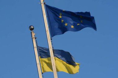 Ukrayna 'nın ulusal bayrağı ve Avrupa Birliği bayrağı gökyüzünün arka planında dalgalanıyor, Kyiv, Ukrayna - 2 Şubat 2024