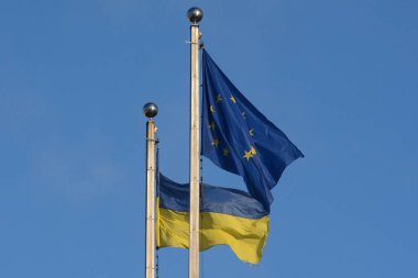 Ukrayna 'nın ulusal bayrağı ve Avrupa Birliği bayrağı gökyüzünün arka planında dalgalanıyor, Kyiv, Ukrayna - 2 Şubat 2024