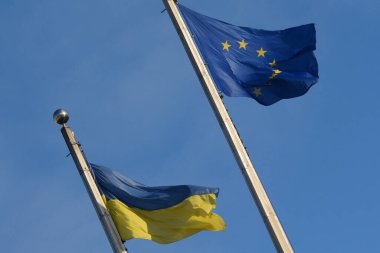 Ukrayna 'nın ulusal bayrağı ve Avrupa Birliği bayrağı gökyüzünün arka planında dalgalanıyor, Kyiv, Ukrayna - 2 Şubat 2024