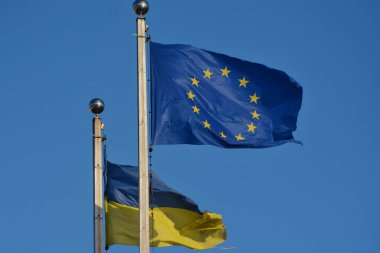 Ukrayna 'nın ulusal bayrağı ve Avrupa Birliği bayrağı gökyüzünün arka planında dalgalanıyor, Kyiv, Ukrayna - 2 Şubat 2024