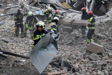 Ukraynalı kurtarma ekipleri, Rusya 'nın Ukrayna' yı işgali sırasında 25 Mart 2024 'te Kyiv' de bir füze saldırısının gerçekleştiği yerde çalışıyorlar..