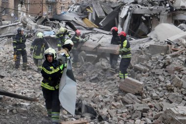 Ukraynalı kurtarma ekipleri, Rusya 'nın Ukrayna' yı işgali sırasında 25 Mart 2024 'te Kyiv' de bir füze saldırısının gerçekleştiği yerde çalışıyorlar..