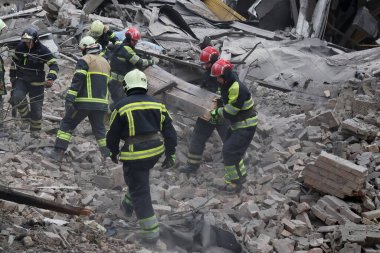 Ukraynalı kurtarma ekipleri, Rusya 'nın Ukrayna' yı işgali sırasında 25 Mart 2024 'te Kyiv' de bir füze saldırısının gerçekleştiği yerde çalışıyorlar..