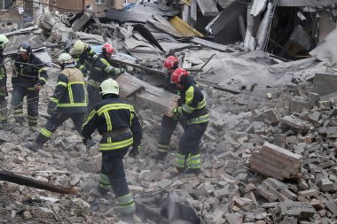 Ukraynalı kurtarma ekipleri, Rusya 'nın Ukrayna' yı işgali sırasında 25 Mart 2024 'te Kyiv' de bir füze saldırısının gerçekleştiği yerde çalışıyorlar..
