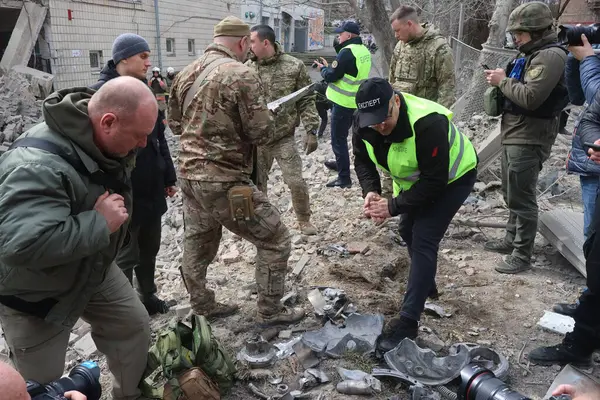 Ukraynalı kurtarma ekipleri, Rusya 'nın Ukrayna' yı işgali sırasında 25 Mart 2024 'te Kyiv' de bir füze saldırısının gerçekleştiği yerde çalışıyorlar..