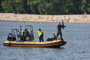21 Temmuz 2024 'te Ukrayna' nın başkenti Kyiv 'de teleferik arızası sonucu Dnipro nehrine düşen adamın arama kurtarma operasyonu sırasında teknedeki kurtarma ekipleri. 