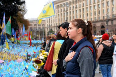 Women stand near a makeshift memorial to fallen Ukrainian soldiers on October 1, 2024 in Kyiv, Ukraine. clipart