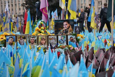 Flowers, flags and portraits on Independence Square near a makeshift memorial to fallen Ukrainian soldiers on October 1, 2024 in Kyiv. clipart