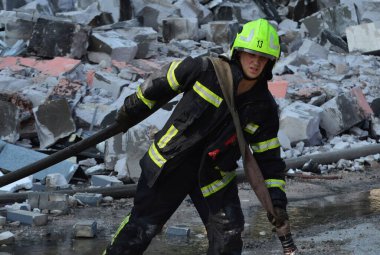 Rusya 'nın Ukrayna' nın Kyiv kentinde Ukrayna 'ya düzenlediği saldırı sırasında, bir Rus insansız hava aracı saldırısının gerçekleştiği yerde itfaiyeciler çalışıyor.
