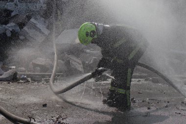 Rusya 'nın Ukrayna' nın Kyiv kentinde Ukrayna 'ya düzenlediği saldırı sırasında, bir Rus insansız hava aracı saldırısının gerçekleştiği yerde itfaiyeciler çalışıyor.