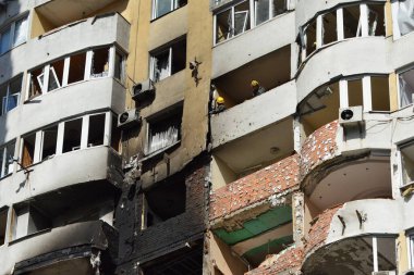 Kurtarma ekipleri, 6 Haziran 2025 'te Ukrayna' nın başkenti Kyiv 'de Rus insansız hava aracı ve füze saldırısının ardından hasarlı bir binadaki yanmış bir apartmanın enkazını temizliyor..