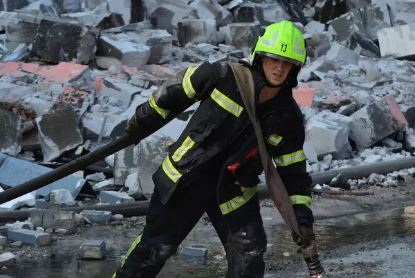 Rusya 'nın Ukrayna' nın Kyiv kentinde Ukrayna 'ya düzenlediği saldırı sırasında, bir Rus insansız hava aracı saldırısının gerçekleştiği yerde itfaiyeciler çalışıyor.