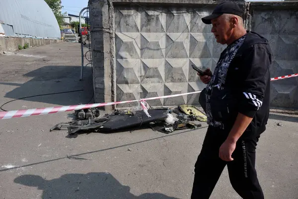 Rusya 'nın Ukrayna, Kyiv' de Ukrayna 'ya saldırdığı sırada, bir Rus İHA' sının çarptığı binanın yanındaki bir Shahed-136 enkazının yanından geçen bir adam görülüyor.