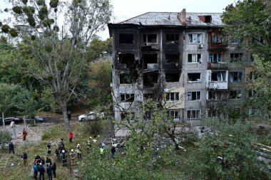 28 Eylül 2025 'te Ukrayna' nın başkenti Kyiv 'de meydana gelen bir Rus saldırısında insanlar bir apartmanın bahçesinde toplandı.