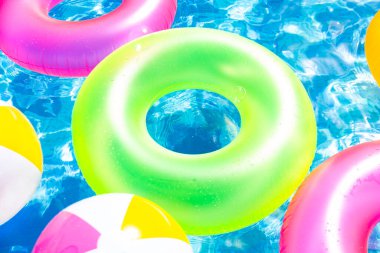 Yüzme yüzüklü şişme havuz ve yüzükler yaz günü mavi arka planda suyun içinde..