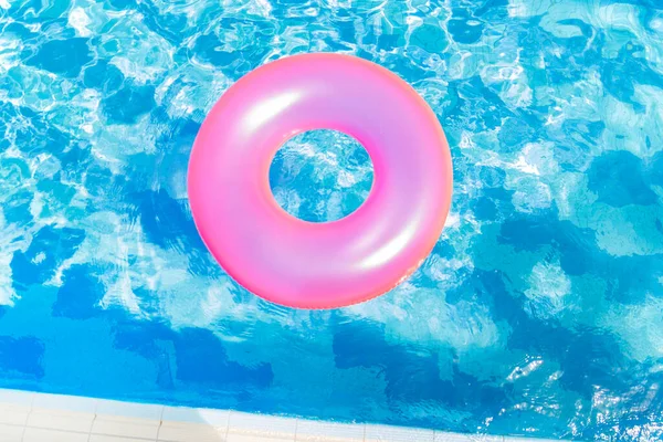 inflatable pool with swimming ring and rings in a water on blue background in the summer day.