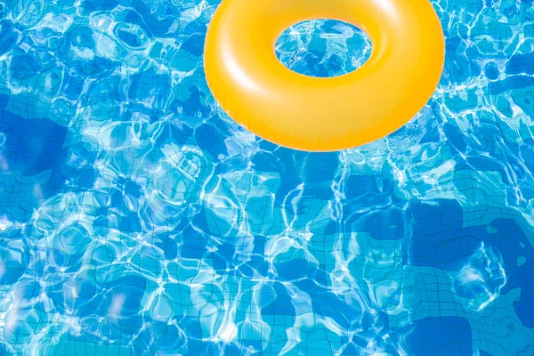 inflatable pool with swimming ring and rings in a water on blue background in the summer day.