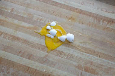 Horizontal shot of a shattered white chicken egg on the floor with copy space.