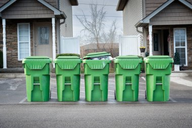 Horizontal shot of condo garbage cans waiting for the dump truck.