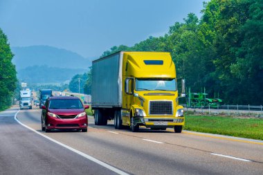 Tennessee otoyolunda giden sarı bir traktörün yatay görüntüsü..