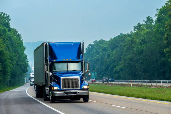 在州际公路上巡航的蓝色牵引拖车钻机的横向拍摄 图库图片