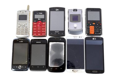 Yatay yakın plan çekimde beyaz arka planda beş farklı nesilden 10 farklı telefon var. Boşluğu kopyala