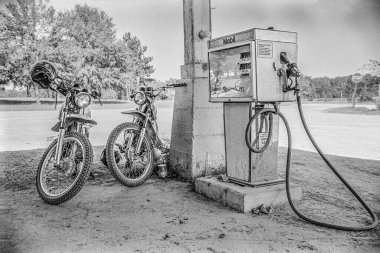 Makedonya, Arkansas, ABD 23 Haziran 2024: 1970 'lerin eski bir taşra mağazasının önünde oturup konuşan iki adamın yatay çekimi.