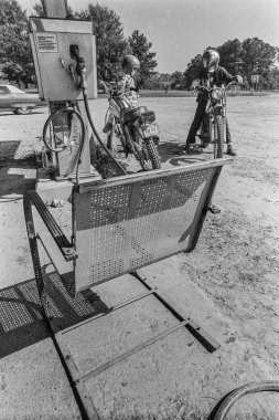 Makedonya, Arkansas, ABD 23 Haziran 2024: 1970 'lerin eski bir taşra mağazasının önünde oturup konuşan iki adamın yatay çekimi.